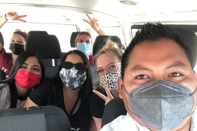 Private Roundtrip Transportation from Cancun Airport to Playa del Carmen - Getting Met at Cancun Airport: Green Shirt and Happy Shuttle Banner